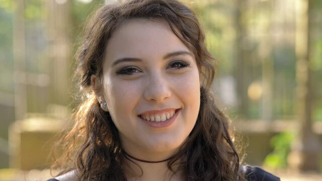 youth, beauty-young beautiful woman at park smiling at camera