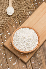 White rice in ceramic bowl. Rice in wooden spoon.
