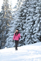 Fototapeta na wymiar Girl on winter snowy fir tree background on ski resort