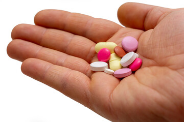 tablet medicines in many different colors in the palm