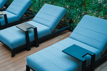Blue poolside sofa on wooden floor - 403114066