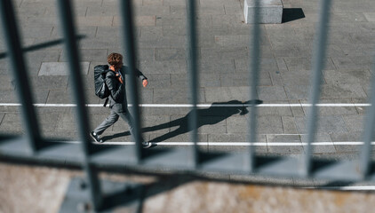 Talks by phone. Young successful businessman in grey formal wear is outdoors in the city