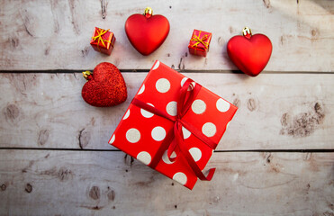 red gift box with hearts on a wooden background.