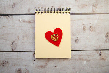 spiral notepad with hearts on wooden background