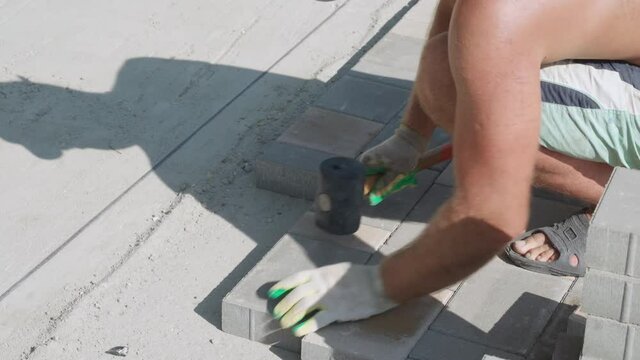 bricklayer lays paving slabs. Close-up. Sound
