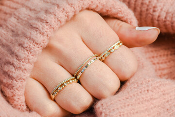 Hand with stackable rings and sweater