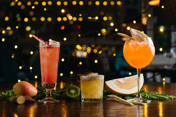 Three exotic cocktails on the table. Sour cocktail, pear cocktail and aperol spritz