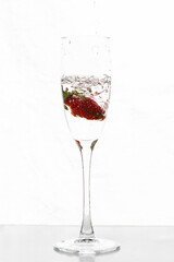 Filling up the champagne glass with strawberry isolated on a white background copy space