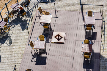 Chairs and tables in a cozy street cafe. Top view