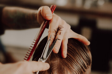 The work of the barbershop. Haircut of a boy in a barbershop. Children's haircut