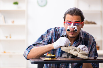 Young male archaeologist studying ancient african stonemask