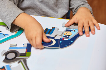 Child playing with puzzles,. The boy is playing in his room. Educational logic toys for kid's..