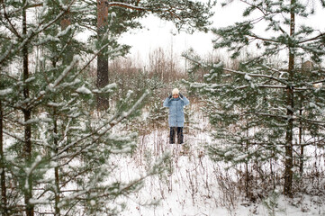 little girl playing with snow in winter forest. Walking and active rest in winter.
