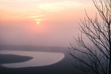 Wschód słońca we mgle nad wodą