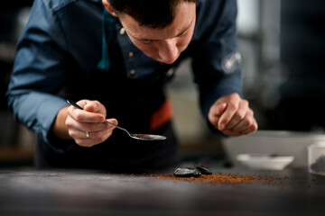 Obraz premium Man holds steel spoon in his hand and carefully lays the ingredients