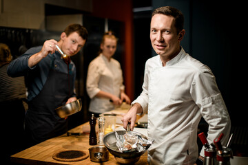 man with frying pan in his hand looks at the camera
