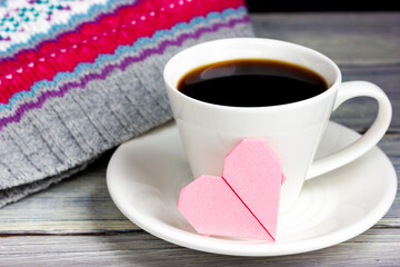 Cup of coffee with a small note in the form of a pink heart. Gift for a loved one