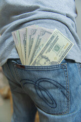 The young man kept his pocket money dollar in his back pocket..Design for money dollar financial business.