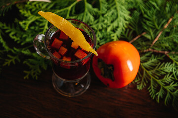 Mulled wine with persimmon and mango on the table in restaurant. Winter and autumn hot alcoholic...