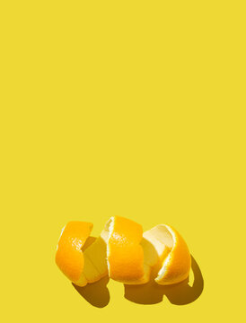 Citrus Fruit Concept With Fresh Orange Peel Spiral On A Bright Yellow Background. Minimal Style Flat Lay With Room For Text