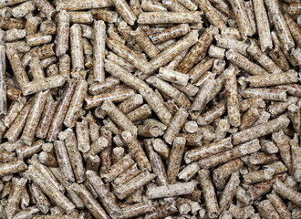 Close up on a pile of compressed wood pellets for use as an eco-friendly renewable organic biofuel or mulch in the garden over a white background
