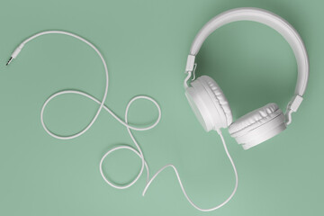 Modern white headphone on cyan background. Music concept.