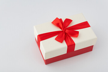 White box with red ribbon on white background. Gift wrap