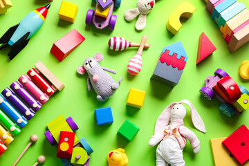 Different toys on green background, flat lay