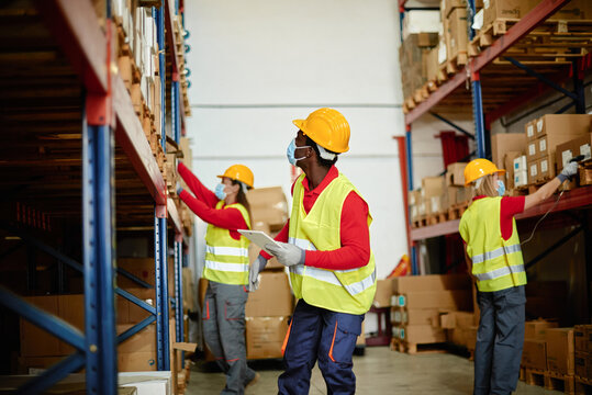 African-American man working in a warehouse with three other workers