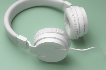 Obraz na płótnie Canvas Close-up image of modern white headphone on cyan background. Music concept.