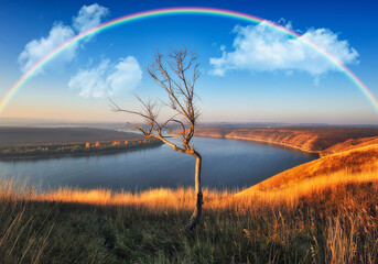 Obraz premium colorful rainbow over river canyon. autumn landscape