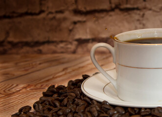 a cup of coffee with beans shallow field of view