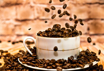 coffee beans falling into a cup of coffee 
