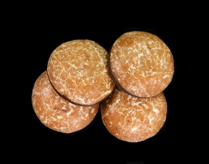 Glazed gingerbread lebkuchens with chocolate isolated on black background. German round gingerbread called 'Lebkuchen' 