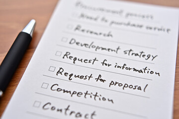 There's a piece of paper on the desk with a "procurement process" checklist. It is focus in Request for proposal.
