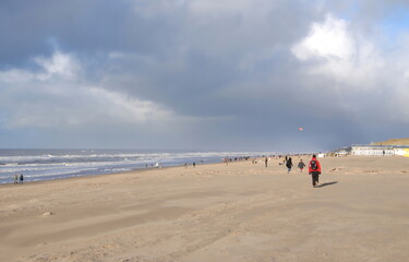 People walking on the beach near Castricum, North Holland, The Netherlands on a winters day