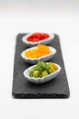 Three small tasting plates with different types of peppers, red yellow and green peppers