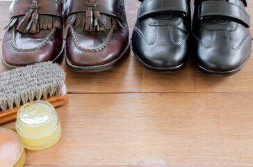 genuine leather shoes on wooden table prepare to clean and care with wax. maintenance concept.