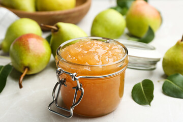Delicious pear jam and fresh fruits on light grey table