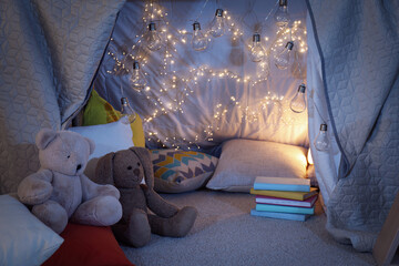 Play tent with toys and pillows indoors, closeup. Modern children's room interior - obrazy, fototapety, plakaty