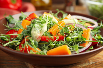 Delicious vegetable salad with microgreen served on wooden table, closeup