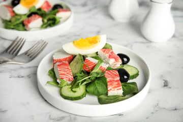 Delicious crab stick salad served on white marble table