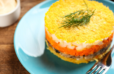 Traditional russian salad Mimosa served on wooden table, closeup