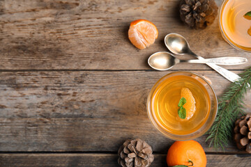 Delicious tangerine jelly on wooden table, flat lay. Space for text