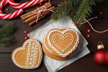 Flat lay composition with tasty heart shaped gingerbread cookies and Christmas decor on wooden table