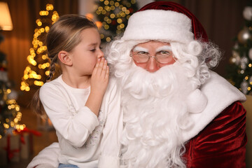 Fototapeta na wymiar Little girl whispering in Santa Claus' ear near Christmas tree indoors