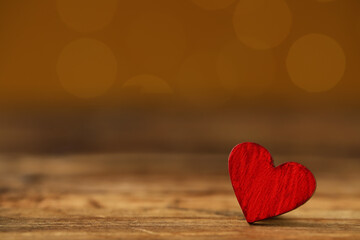 Fototapeta premium Red decorative heart on wooden table against yellow background, space for text. Valentine's Day