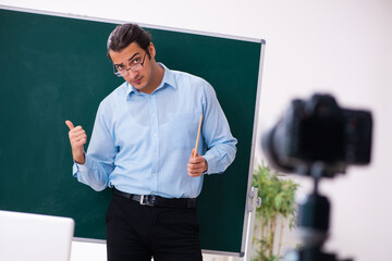 Young handsome teacher recording video for his blog