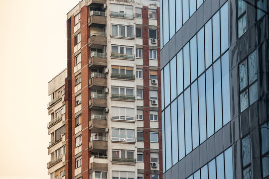Traditionnal communist housing in Belgrade. These kind of high rises are symbols of the brutast architecture, with a modern office building with mirror windows in front