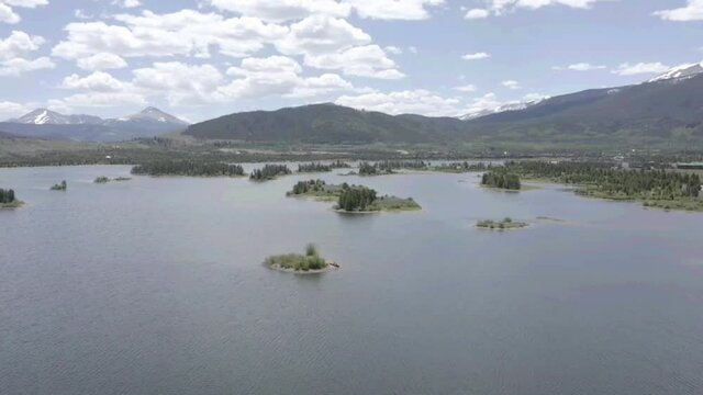 Drone pass over small inland with people pushing off in a canoe 